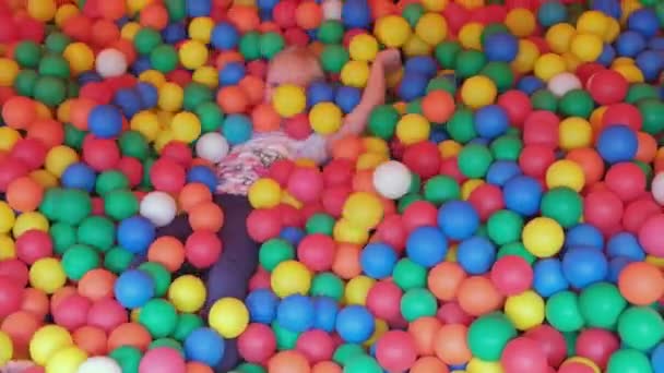 Joyeux Blonde Petite Fille Couchée Sur Des Boules Plastique Multicolores — Video