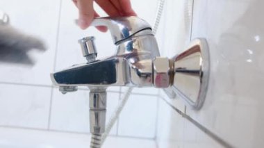 Woman in rubber gloves cleans shower watering can, bathroom sink in bathroom. Housework cleaning concept.