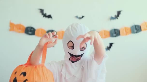 穿着鬼装束的小女孩在恐怖故事中害怕和玩耍 万圣节小孩在家里 孩子们准备好了要不要去度假了 党的假日概念 — 图库视频影像