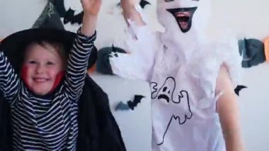 4 bin. Cadılar Bayramı çocukları. Vampir gibi giyinmiş küçük kızlar ve hayalet kostümü evde dans edip zıplıyorlar. Çocuk şeker mi şaka mı tatiline hazır. Parti tatil konsepti