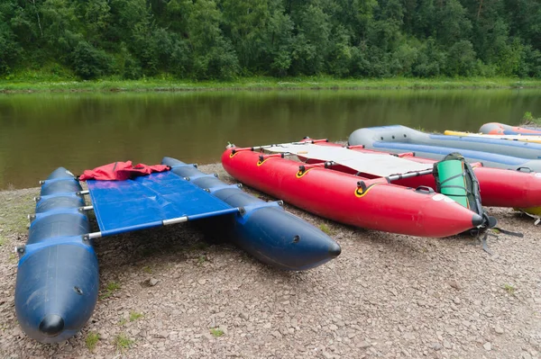 There are many inflatable boats at the pier ready for rafting down the mountain river. — Stock Photo, Image