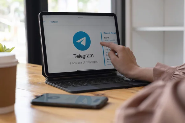 ЧЬЯН-ИЛЕНД, 29 сентября 2021 года: Женщина указывает на айпад с сервисом социальной сети Telegram на экране. iPhone 10 был создан и разработан Apple inc. — стоковое фото