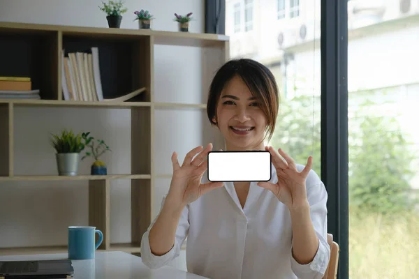 Μια γυναίκα ενθουσιασμένος έκπληξη και δείχνει οθόνη του κινητού τηλεφώνου. Λευκή οθόνη για τη διαφήμισή σας. — Φωτογραφία Αρχείου