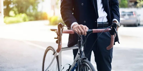 Przystojny młody azjatycki biznesmen w garniturze uśmiecha się z rowerem iść do pracy rano — Zdjęcie stockowe