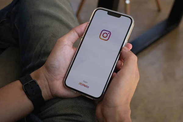 CHIANG MAI, TAILANDIA - 07 NOV 2021: Un hombre de mano sosteniendo el iphone con el logotipo de instagram de meta. Carretes de Instagram para hacer videos cortos y la historia — Foto de Stock