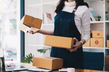 İşletme sahibi ürünleri evde kontrol edip paketliyor. Başarılı KME girişimci kavramı.