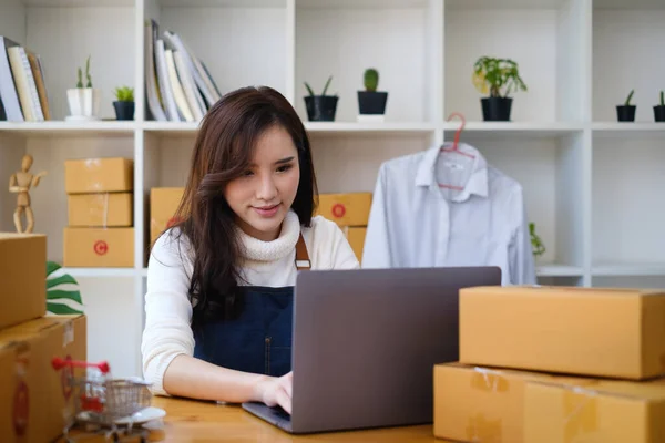 Geschäftsinhaberin überprüft Kundenaufträge auf ihren Laptops und verpackt Produkte zu Hause. Erfolgreiches Konzept für KMU-Unternehmer. — Stockfoto