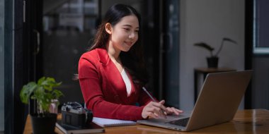 Sanatçı ya da yaratıcı tasarımcı Asyalı kadın dizüstü bilgisayarına yeni proje tasarımı çiziyor.