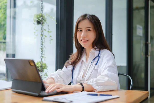 Portret van een vrouwelijke arts die op kantoor met een digitale tablet werkt. Plastische chirurgie en schoonheidskliniek concept — Stockfoto