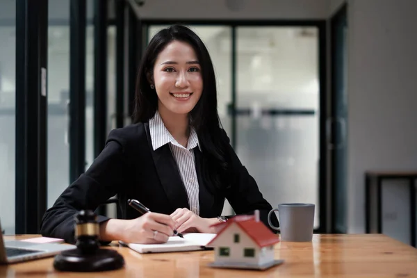 Affärskvinna eller juridisk rådgivare sitter träbord på kontoret. Juridik, juridiska tjänster, rådgivning, domarauktion och fastighetsbegreppet. — Stockfoto