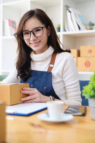 Kleinunternehmerin mit Paketkasten und arbeitet bei ihr zu Hause, um Bestellungen zu verpacken, bevor sie sie an den Kunden schickt. Freiberufliches Arbeiten und KMU-Unternehmerkonzept. — Stockfoto