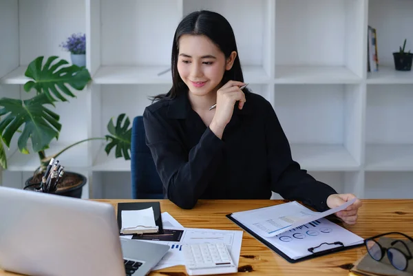 Mujer de negocios asiática analizando estadísticas financieras por papeleo y videollamada con su equipo de negocios. —  Fotos de Stock