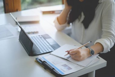 Dijital tablet ve yönetim ile çalışan bilişim danışmanı büyük veriler ve şirketin mali belgesini analiz.