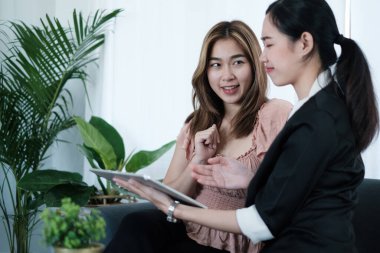 Sigorta acentesi yaşlılar için sağlık sigortası planı öneriyor ve açıklıyor. Asyalı kadın hayat planını seçiyor ve sigortayı kurtarıyor..