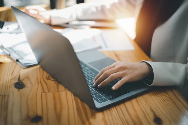 Close up Mujer de negocios que utiliza la calculadora en el ordenador portátil para hacer finanzas matemáticas en escritorio de madera en la oficina, impuestos, contabilidad, estadísticas y el concepto de investigación analítica. — Foto de Stock