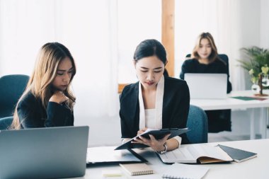 Asyalı iş adamları görüşlerini paylaşıyor ve toplantı odasında birlikte danışmanlık yapıyorlar. Mali danışman ve muhasebe kavramı.