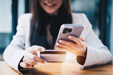 Sanal dijital varlık ve metaevren ile ödeme yapmak için çevrimiçi alışveriş uygulaması ve doldurma numarası için kredi kartı yazmaktan hoşlanan kadınlar.