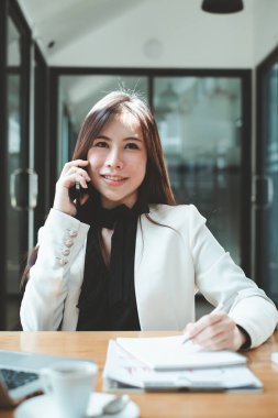 Asyalı işletme sahibi paket ürünlerinden önce cep telefonuyla konuşan müşterilere gönderilecek adresi doğruladı. Başarılı KME girişimci kavramı.