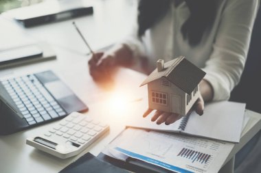 Ev modelliği yapan bir kadın. Gayrimenkul Değerlendirme ve Teftiş ve Sigorta Konsepti..