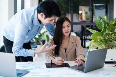 Analitik istihbarat konsepti. İş adamları grubu, toplantıda yatırım için dizüstü bilgisayarda mevcut mali ve ekonomik konuları tartışıyor.