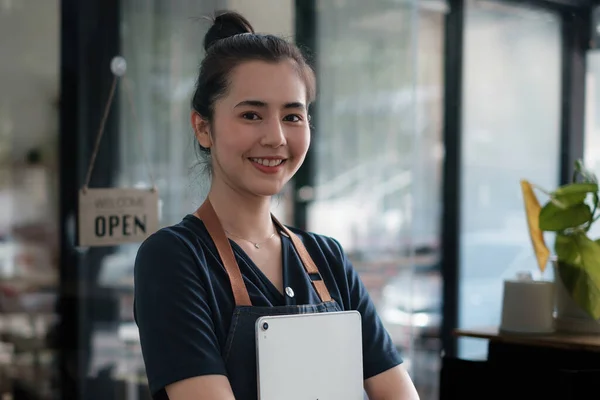 카페 문을 열고 웃는 아시아인 여성의 모습. SME 기업 판매업 개념. — 스톡 사진