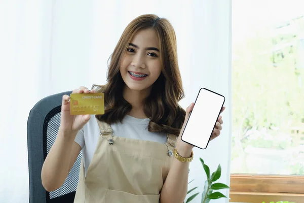 Νεαρή γυναίκα δείχνει το smartphone κενή οθόνη και πιστωτική κάρτα. Αγορές online και on-line έννοια πληρωμής — Φωτογραφία Αρχείου