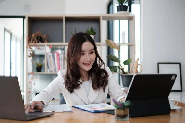 사무실에서 일하면서 고객을 기다리고 웃는 바쁜 아시아 장관의 모습. 사업적 금융 개념. — 스톡 사진