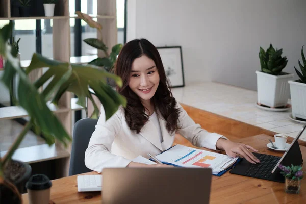 Portret van drukke Aziatische secretaris die glimlacht en wacht op de klant terwijl hij op kantoor werkt. Business Finance concept. — Stockfoto