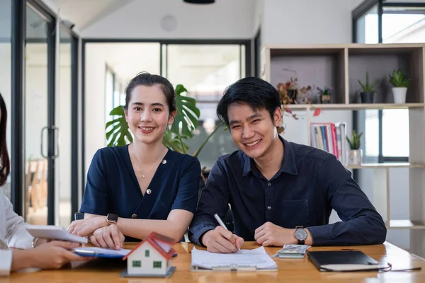 Una pareja joven y feliz recibe una ganga maravillosa después de firmar un contrato para comprar una casa. Concepto inmobiliario. —  Fotos de Stock