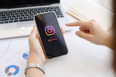 CHIANG MAI, THAILAND - MAR 06, 2022: iPhone 'da Instagram uygulaması kullanan bir kadın. Meta 'dan kısa videolar yapmak için Instagram makaraları.