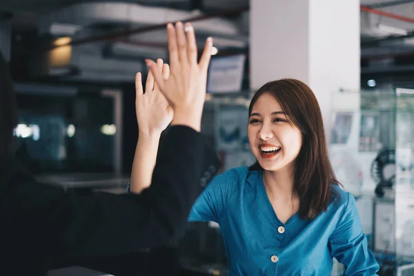 Mulher de negócios asiática e seus parceiros dão uns aos outros cinco altos como eles celebram um projeto de construção de equipe de sucesso. — Fotografia de Stock