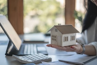 Ev modelliği yapan bir kadın. Gayrimenkul Değerlendirme ve Teftiş ve Sigorta Konsepti..