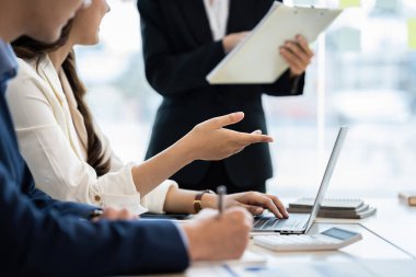 Bir grup Asyalı iş adamı yeni finansal projeyi analiz etmek ve planlamak için tartışıyor ve beyin fırtınası yapıyor.