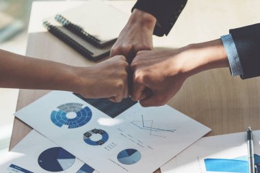 Asyalı iş adamları başarılı bir takım oluşturma projesini kutlarken birbirlerine başarı sembolü gösteriyorlar..