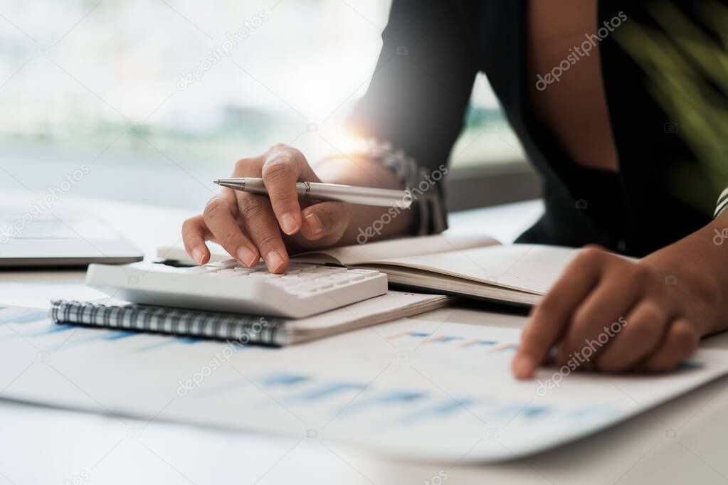 Business woman hand holding pencil and financial paperwork looking at bank savings account application on laptop computer. account or saving money or insurance concept.