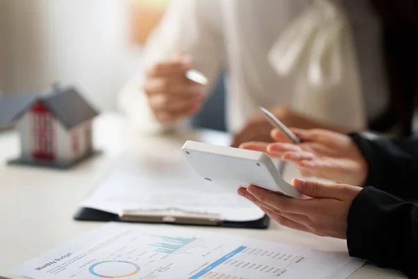 Bankir eller agent beräkna priset för köp eller lån hus och visar för kunden. Fastighetskoncept. — Stockfoto