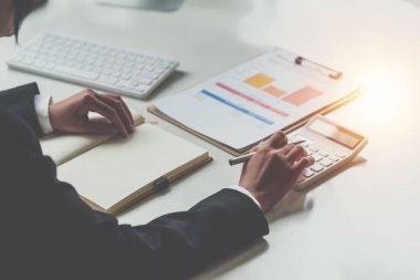 Asyalı İş Kadını veya Muhasebeci, masa, hesap, danışma, denetim ve kaydetme kavramında hesap makinesi ve evrak işleriyle matematik ve analiz yapar..