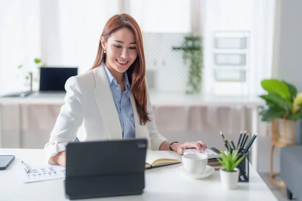 Mujer de negocios asiática que tiene videollamada con el equipo de negocios para consultar sobre el plan de negocios de la empresa. Reunión de equipo en línea video conferencia. — Foto de Stock