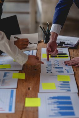 Analitik istihbarat konsepti. İş adamları grubu, toplantıda yatırım için dizüstü bilgisayarda mevcut mali ve ekonomik konuları tartışıyor.