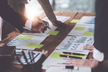 Analitik istihbarat konsepti. İş adamları grubu, toplantıda yatırım için dizüstü bilgisayarda mevcut mali ve ekonomik konuları tartışıyor.