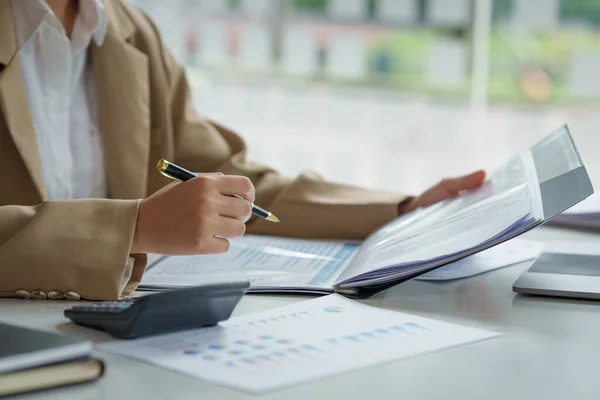 Feche a mão mulher de negócios usando calculadora para calcular os resultados financeiros e orçamento da empresa. Conceito de Auditoria de Contas. — Fotografia de Stock