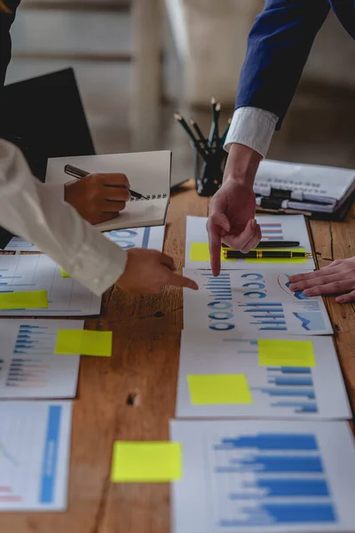 Analitik istihbarat konsepti. İş adamları grubu, toplantıda yatırım için dizüstü bilgisayarda mevcut mali ve ekonomik konuları tartışıyor.