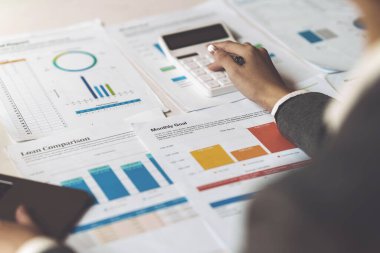 Asyalı İş kadını, cep telefonuyla konuşan iş ekibiyle teknik fiyat grafiğini ve göstergeyi analiz etmeye çalışıyor. Hesap ya da tasarruf parası ya da sigorta kavramı.