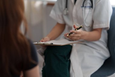 Doktor hastaya danışır ve klinikte sağlıklı besin sunar..