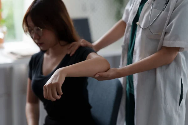 Een vrouw die de revalidatietherapie pijn doet in de kliniek. Dokter of fysiotherapeut. Arts of fysiotherapeut onderzoekt de behandeling van gewonde arm en schouder. — Stockfoto