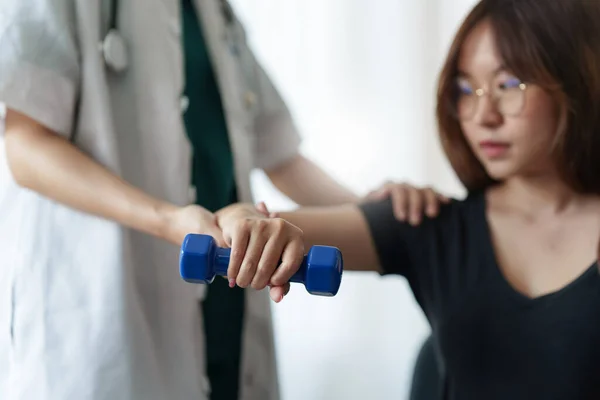 Een vrouw die de revalidatietherapie pijn doet in de kliniek. Dokter of fysiotherapeut. Arts of fysiotherapeut onderzoekt de behandeling van gewonde arm en schouder. — Stockfoto