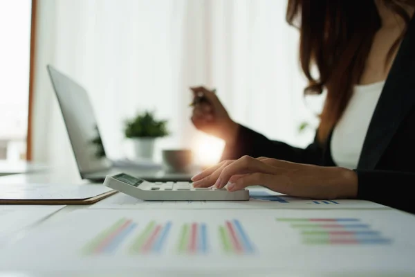 Close up Mujer de negocios mano utilizando la calculadora para calcular los resultados financieros de las empresas y el presupuesto. Concepto de auditoría de cuenta. — Foto de Stock