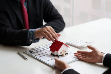 Ev almak için anlaşma imzaladıktan sonra iş adamı ya da temsilci ev veriyor. Banka müdürü ve emlak konsepti.