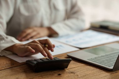 Şirketin mali sonuçlarını ve bütçesini hesaplamak için hesap makinesi kullanarak Business Woman Hand 'i kapatın. Hesap Denetim Kavramı.