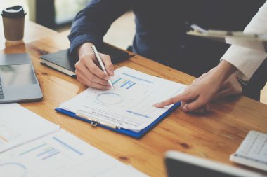 Bir grup Asyalı iş adamı yeni finansal projeyi analiz etmek ve planlamak için tartışıyor ve beyin fırtınası yapıyor.